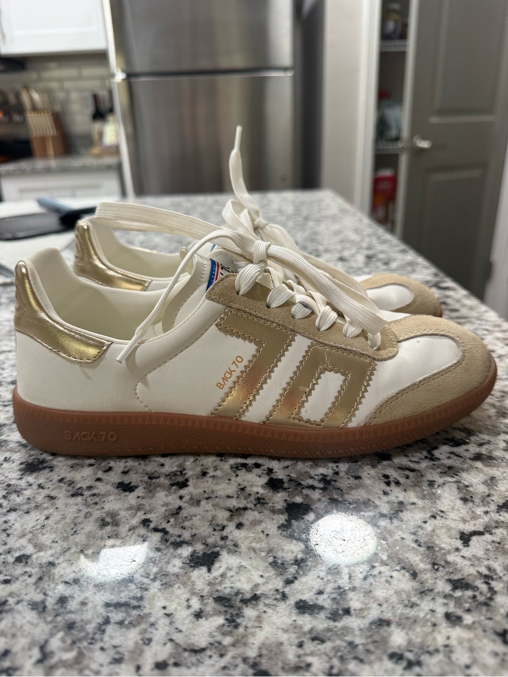 - BACK 70 sneakers. White and gold.   Small stain on the top on left shoe.